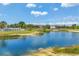 Expansive pond with inviting views of condos, blue skies, and tropical foliage, perfect for serene living at 175 Kings Hwy # 1014, Punta Gorda, FL 33983
