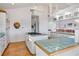 White kitchen with island, gas cooktop, wood floors and access to Gathering room at 13044 Via Cassia, Placida, FL 33946