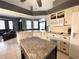 Open kitchen with island, granite countertops, and white cabinets at 8 Sportsman Ter, Rotonda West, FL 33947