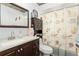 Clean bathroom with dark wood vanity, seashell shower curtain, and granite countertop at 1361 Newton St, Port Charlotte, FL 33952