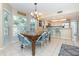 Bright dining area with a granite table and blue chairs, near kitchen at 7536 Palm Island S Dr # 1511, Placida, FL 33946