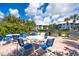 Outdoor patio with multiple grills, tables, blue chairs and brick pavers at 7454 Palm Island Dr # 3313, Placida, FL 33946
