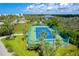 Blue tennis court with green perimeter fencing and palm trees at 7454 Palm Island Dr # 3313, Placida, FL 33946