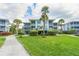 Two-story building with light-colored siding, balconies, and lush landscaping at 7454 Palm Island Dr # 3313, Placida, FL 33946