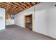 A carpeted basement area featuring exposed rafters and an unfinished doorway at 342 Green Dolphin Dr, Placida, FL 33946