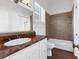 Bathroom featuring neutral tile in the shower, white cabinets and trim and wood-look tile flooring at 342 Green Dolphin Dr, Placida, FL 33946