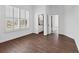 Bright bedroom with wood-look tile flooring, plantation shutters, and a view into the bathroom at 342 Green Dolphin Dr, Placida, FL 33946