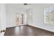 Bedroom featuring dark-wood look tile flooring, white trim, and a door to the outside patio at 342 Green Dolphin Dr, Placida, FL 33946
