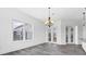 Bright dining room features wood-look tile flooring, modern chandelier, and French door access at 342 Green Dolphin Dr, Placida, FL 33946