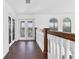 Bright upstairs hallway with wood-look tile flooring, natural light, and modern white railing at 342 Green Dolphin Dr, Placida, FL 33946