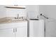 Functional laundry room with a utility sink, cabinetry, and modern washer and dryer at 342 Green Dolphin Dr, Placida, FL 33946
