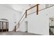 Bright and airy living room with soaring ceilings, wood staircase, tile floors, and a decorative front door at 342 Green Dolphin Dr, Placida, FL 33946