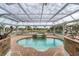 Enclosed pool area with a hot tub overlooking a lake at 342 Green Dolphin Dr, Placida, FL 33946