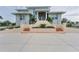 Two-story house with light teal exterior, multi-tiered entryway, and palm trees at 342 Green Dolphin Dr, Placida, FL 33946