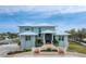 Two-story house with light teal exterior, multi-tiered entryway, and palm trees at 342 Green Dolphin Dr, Placida, FL 33946
