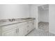 Bathroom with double vanity, granite countertop and patterned floor at 8099 Walbert St, Port Charlotte, FL 33981