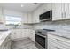 Modern kitchen with white cabinets, stainless steel appliances, and an island at 8099 Walbert St, Port Charlotte, FL 33981