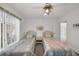 Bright bedroom with two twin beds, a ceiling fan and plenty of natural light at 12440 Placida Rd, Placida, FL 33946