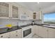 Bright kitchen with white cabinets, granite counters, and water view at 12440 Placida Rd, Placida, FL 33946