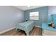 Bright bedroom with blue walls, light wood floors, and a ceiling fan at 13525 Dibella Ave, Port Charlotte, FL 33981