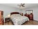 A charming bedroom features warm wood accents, a ceiling fan, and a delightful sea themed quilt at 13525 Dibella Ave, Port Charlotte, FL 33981