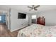 This bedroom features a ceiling fan, dresser, large tv, and good natural light at 13525 Dibella Ave, Port Charlotte, FL 33981