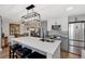 Updated kitchen featuring stainless steel appliances, sleek gray cabinetry, and a spacious quartz island with seating at 13525 Dibella Ave, Port Charlotte, FL 33981