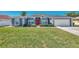 Single-story home with gray exterior and red door at 2341 Rio De Janeiro Ave, Punta Gorda, FL 33983