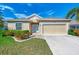 One-story home with attached garage, landscaping, and a paved driveway at 584 Gadsen St, Englewood, FL 34223