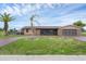 Single story home with a stone facade and well-manicured lawn at 76 Caddy Rd, Rotonda West, FL 33947