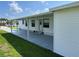 White mobile home with covered patio and lawn at 8485 Nighthawk Dr, Englewood, FL 34224