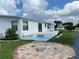 Side view of a white mobile home with a patio at 8485 Nighthawk Dr, Englewood, FL 34224