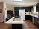 Modern kitchen with island, dark cabinetry, stainless steel appliances, and laminate floors at 8485 Nighthawk Dr, Englewood, FL 34224