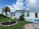 Mobile home with a palm tree and patio area at 8485 Nighthawk Dr, Englewood, FL 34224