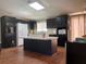 Open concept kitchen with island, dark cabinetry, and breakfast bar at 8485 Nighthawk Dr, Englewood, FL 34224