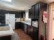Modern kitchen with dark wood cabinets, stainless steel appliances, and a skylight at 8485 Nighthawk Dr, Englewood, FL 34224