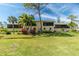 Building exterior showcasing a large, well-maintained lawn and tropical landscaping at 4260 Placida Rd # 9B, Englewood, FL 34224