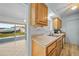 Kitchen with wood cabinets, tile backsplash and view to dining area at 13478 Santa Rosa Ave, Port Charlotte, FL 33981