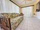 Sunroom with tiled floors, floral couch, and access to backyard at 13468 Romford Ave, Port Charlotte, FL 33981