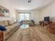 Living room with wood-look tile floors and wicker furniture at 13468 Romford Ave, Port Charlotte, FL 33981