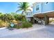 View of home's exterior, driveway, and golf cart, showing the elevated position and landscaping at 431 Kettle Harbor Dr, Placida, FL 33946