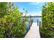 Wooden dock with lush greenery on either side providing access to the water at 431 Kettle Harbor Dr, Placida, FL 33946