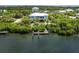 Aerial photo of a light blue house with private dock and lush landscaping at 431 Kettle Harbor Dr, Placida, FL 33946