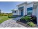 Front entrance of a home with a walkway, landscaping, and blue accents at 14207 Union Hall Ave, Port Charlotte, FL 33981
