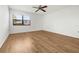 Bright bedroom featuring hardwood floors, a ceiling fan, and a window providing natural light at 104 Park Forest Blvd, Englewood, FL 34223