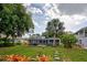 Spacious backyard with lush landscaping, screened patio, and shed at 110 S Oxford Dr, Englewood, FL 34223