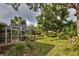 Large backyard with screened patio and lush tropical landscaping at 110 S Oxford Dr, Englewood, FL 34223