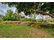 Landscaped backyard with tiered gardens and mature trees at 110 S Oxford Dr, Englewood, FL 34223