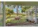Screened patio overlooking a large backyard with tropical landscaping at 110 S Oxford Dr, Englewood, FL 34223