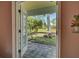 View of backyard through French doors, showcasing patio and lush greenery at 110 S Oxford Dr, Englewood, FL 34223